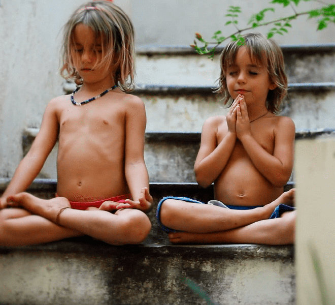 Two siblings meditate side by side